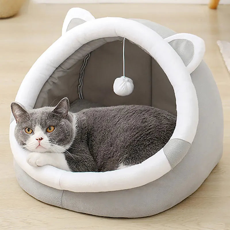 Cama acogedora para gato con orejas y juguete colgante, ideal para descanso y diversión de mascotas