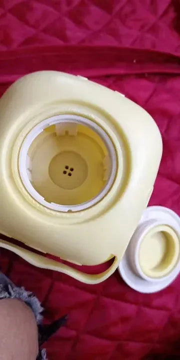 Bebedero portátil para mascotas amarillo con tapa blanca sobre funda roja