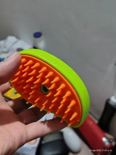 Cepillo masajeador para mascotas con cerdas naranjas y base verde, ideal para cuidado y bienestar canino