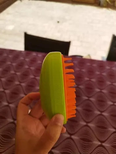 Cepillo de mascota verde y naranja para pelaje, ideal para cuidado diario y bienestar animal