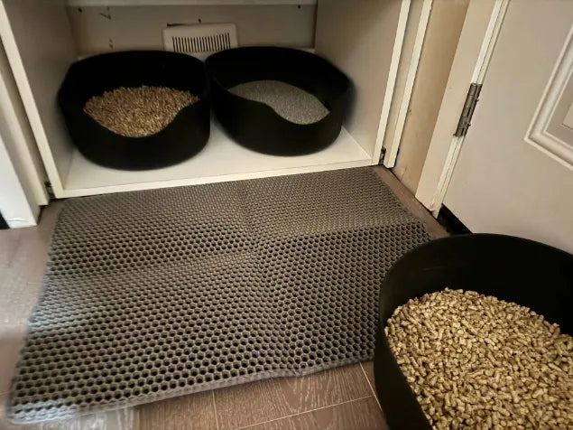 Alfombra antideslizante para comederos de mascotas con comederos negros y pienso en interior hogareño